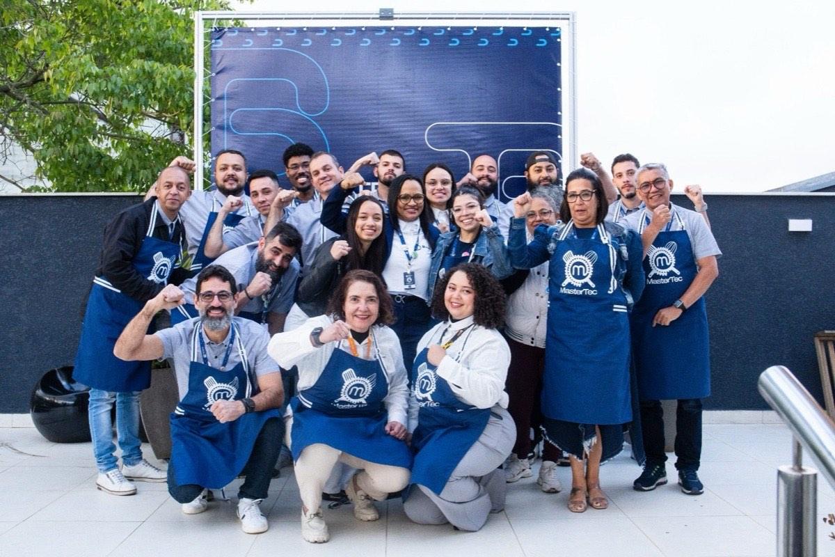 Equipe Tecbas em pose descontraída no painel da empresa